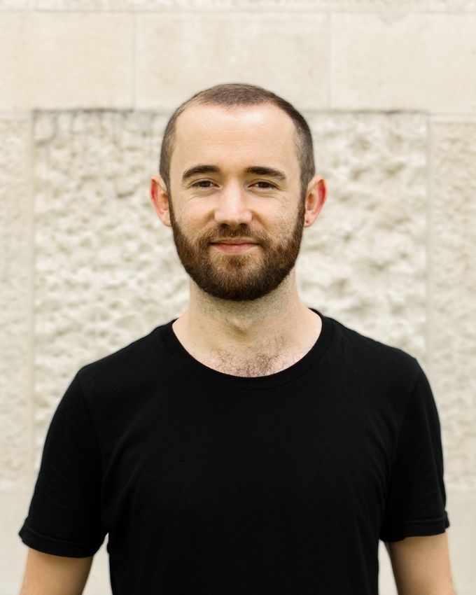 Tom Norman standing in front of a stone wall